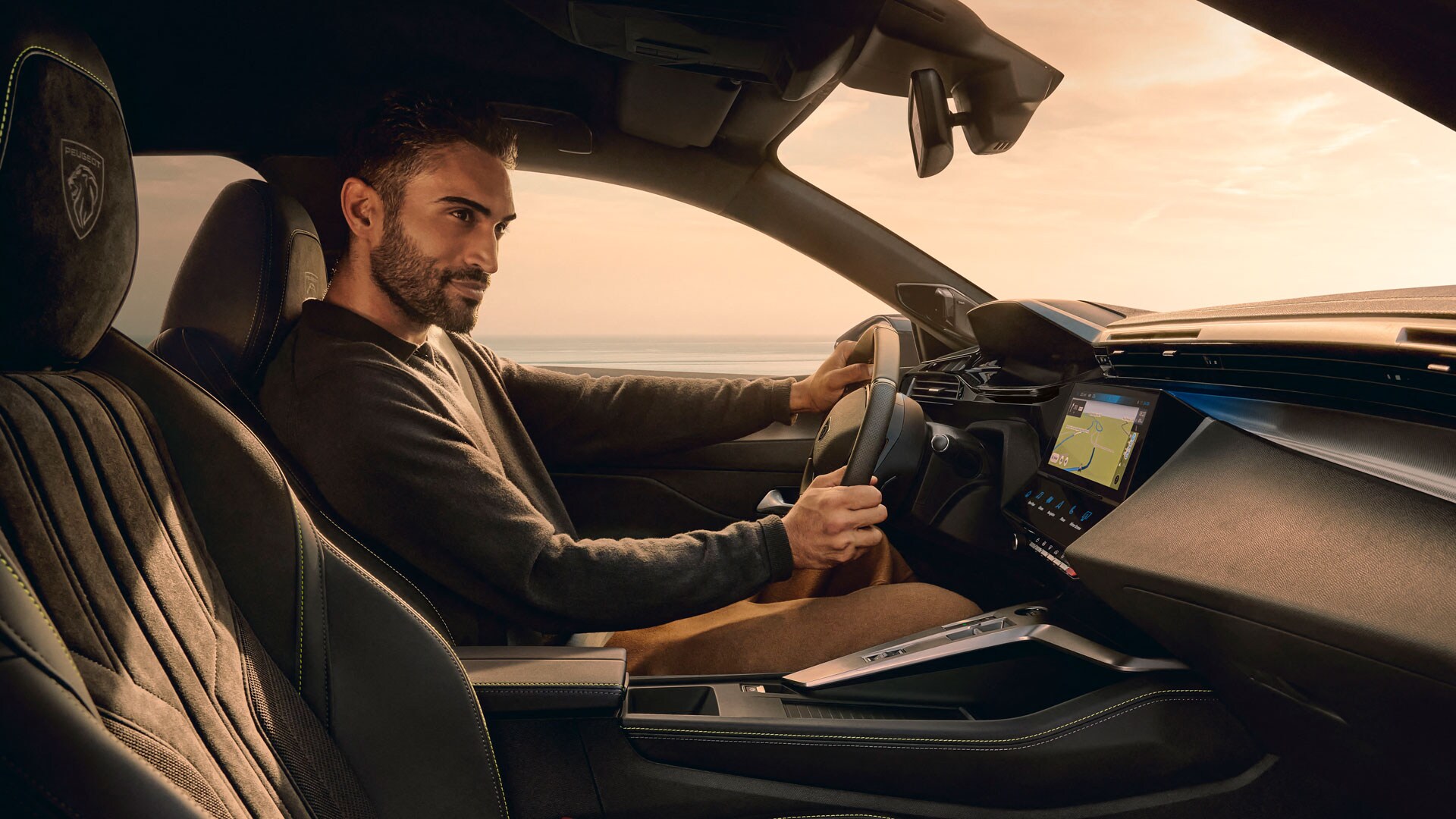 Heckansicht des PEUGEOT E-408 im goldenen Licht des Sonnenuntergangs